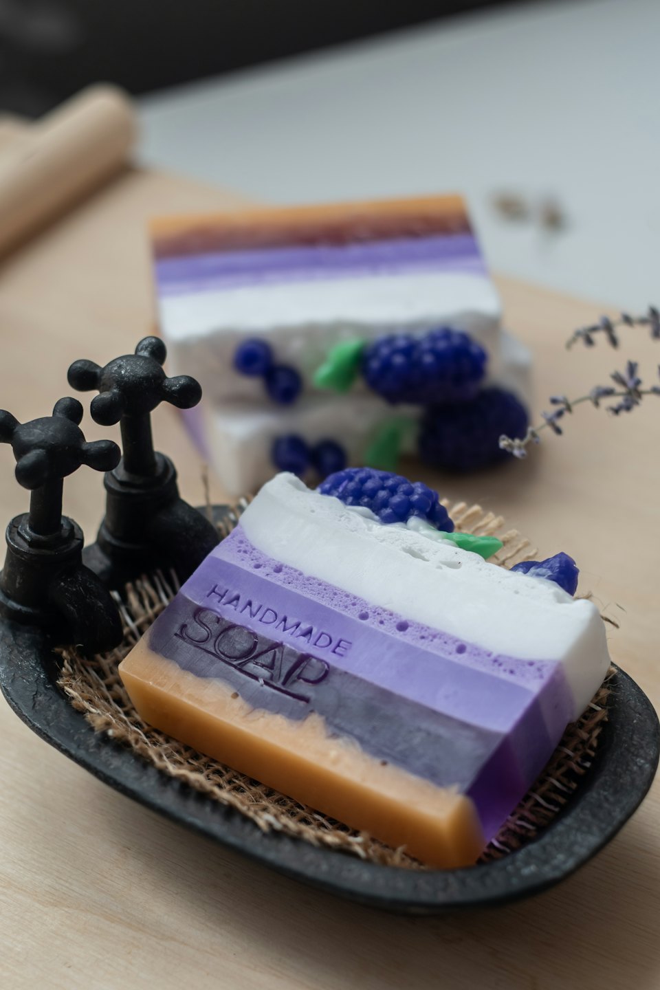 Saponi artigianali alla lavanda che sembrano dolci su un piatto rustico.