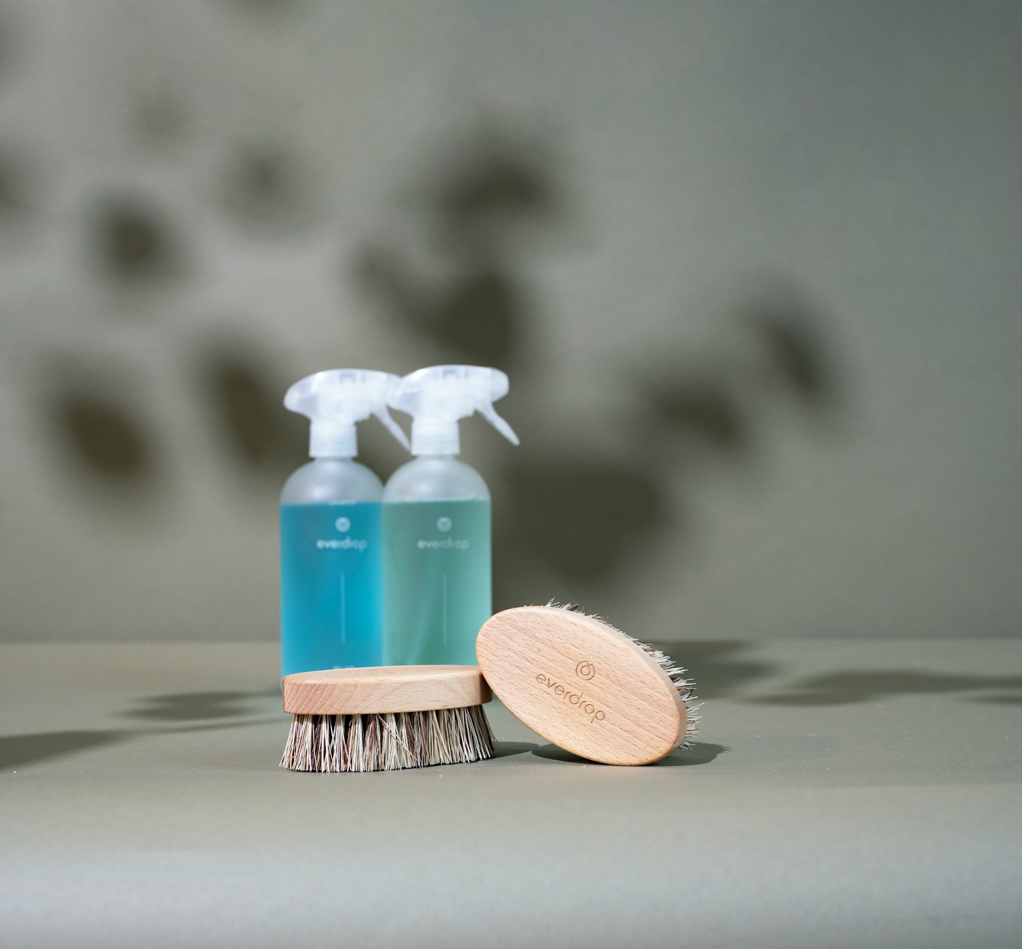 Due flaconi spray ecologici e spazzole di legno.